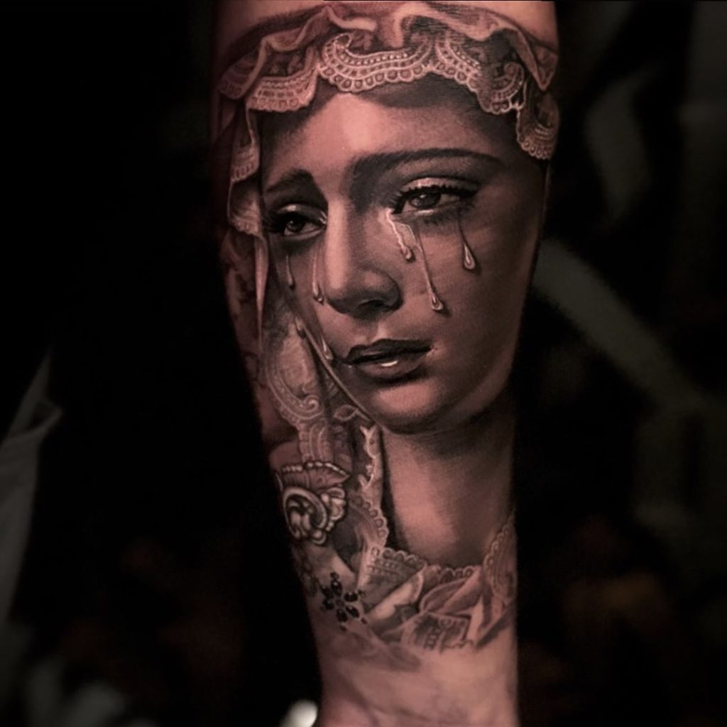 涙を流す聖母マリア像のタトゥー