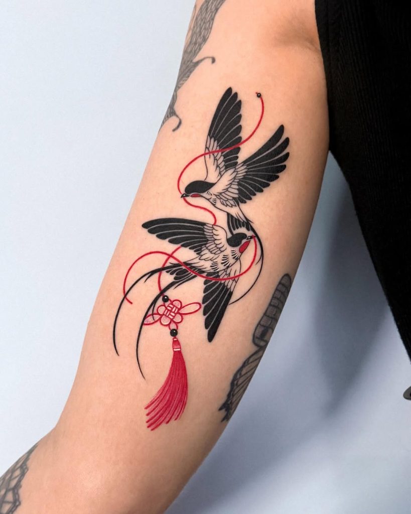 腕につがいの燕(ツバメ)のタトゥー