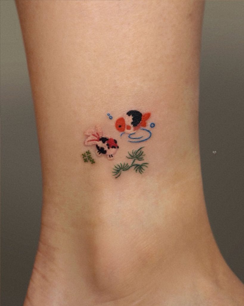 A cute one-point goldfish tattoo featuring a tiny fishbowl on the ankle